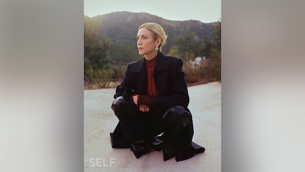 Brittany Snow in a black suit and red turtleneck for Self Magazine