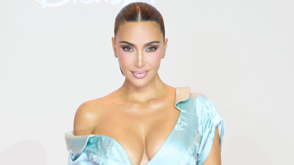 金·卡戴珊 (Kim Kardashian) 身穿藍色連衣裙擺出姿勢