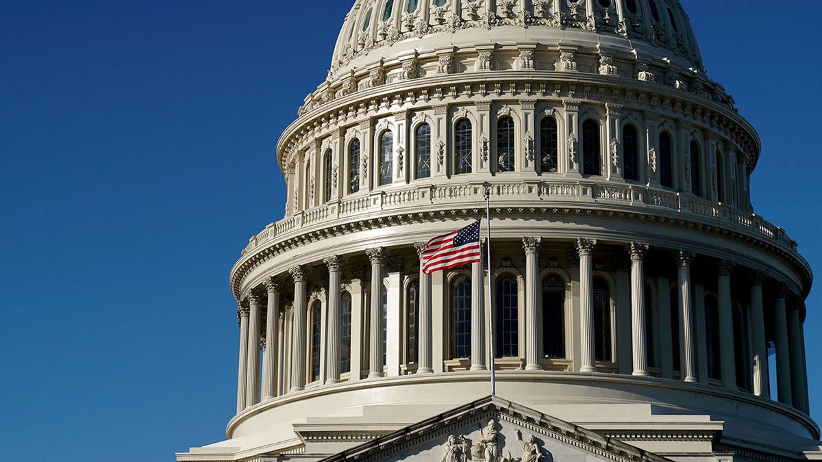 The dome of the United States Capitol with the flag flying.