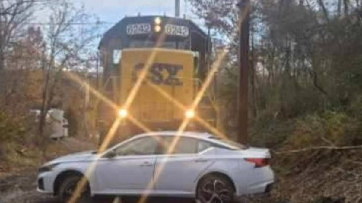 Sedan perpendicular in front of train
