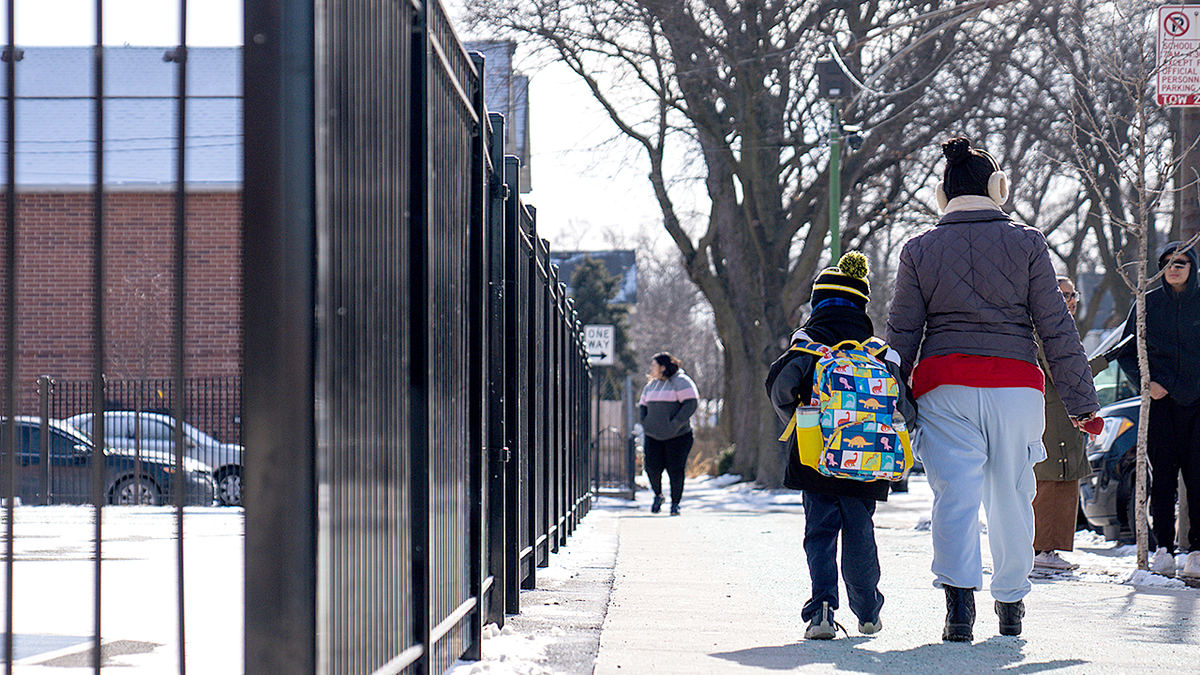 Student and parent walking outside in snow
