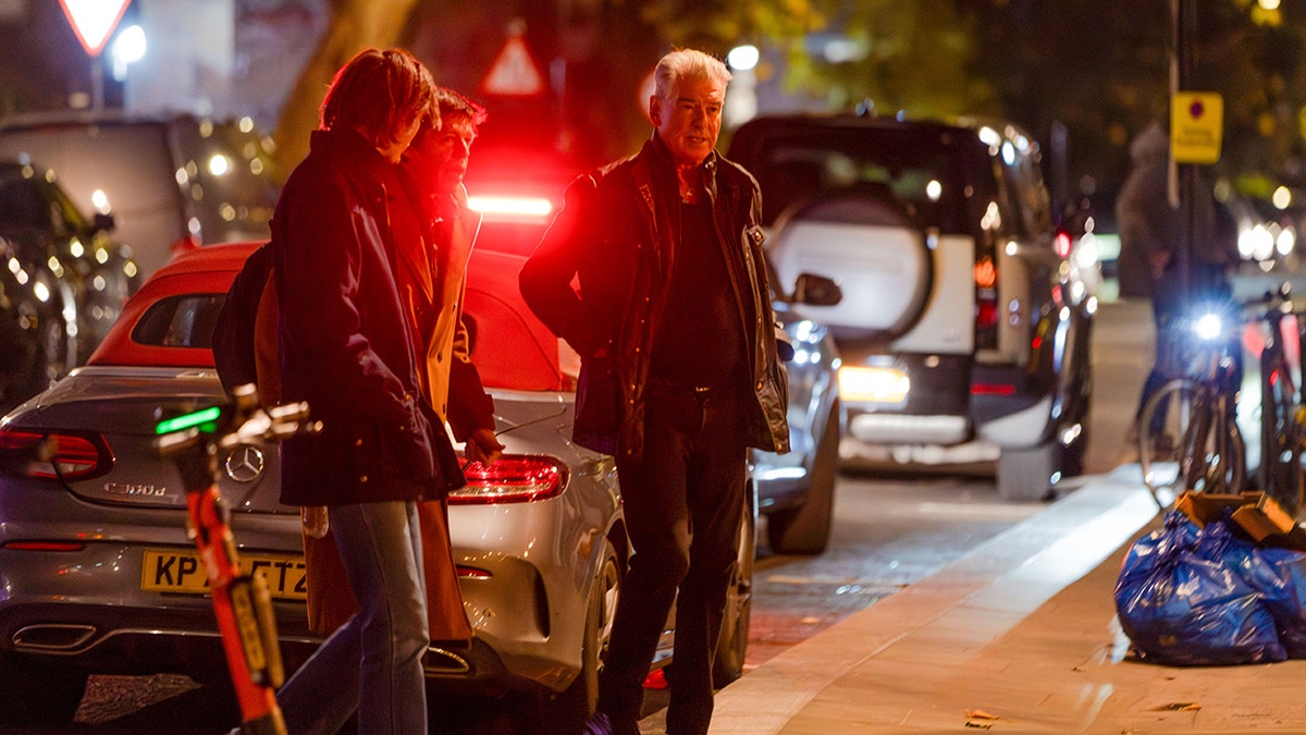 Pierce Brosnan stands with his sons Christopher and Dylan Brosnan on a London street near Dorian restaurant after a family dinner.