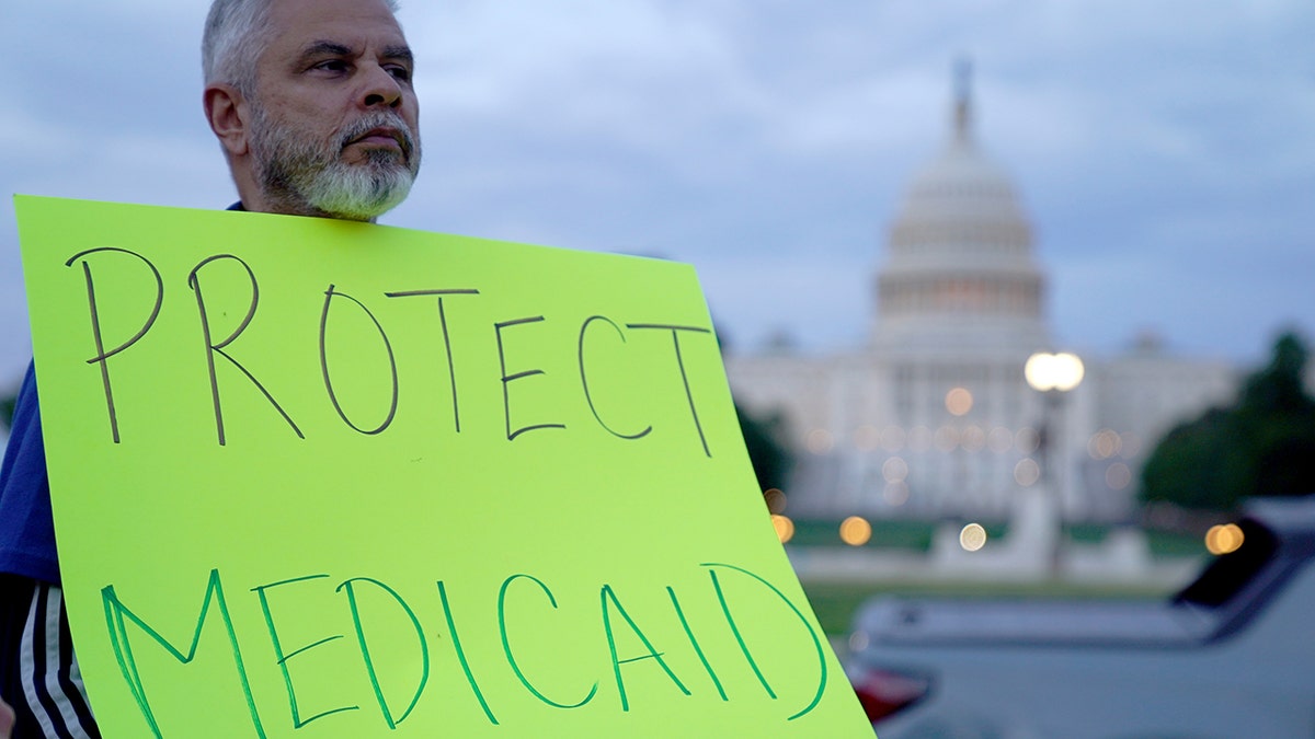 Protester holds sign amid government shutdown this year