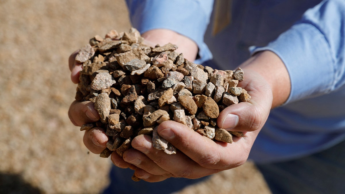 Matt Green, supervisor de minería/trituración de MP Materials, muestra el mineral triturado antes de enviarlo al molino en la mina de tierras raras de MP Materials en Mountain Pass, California.
