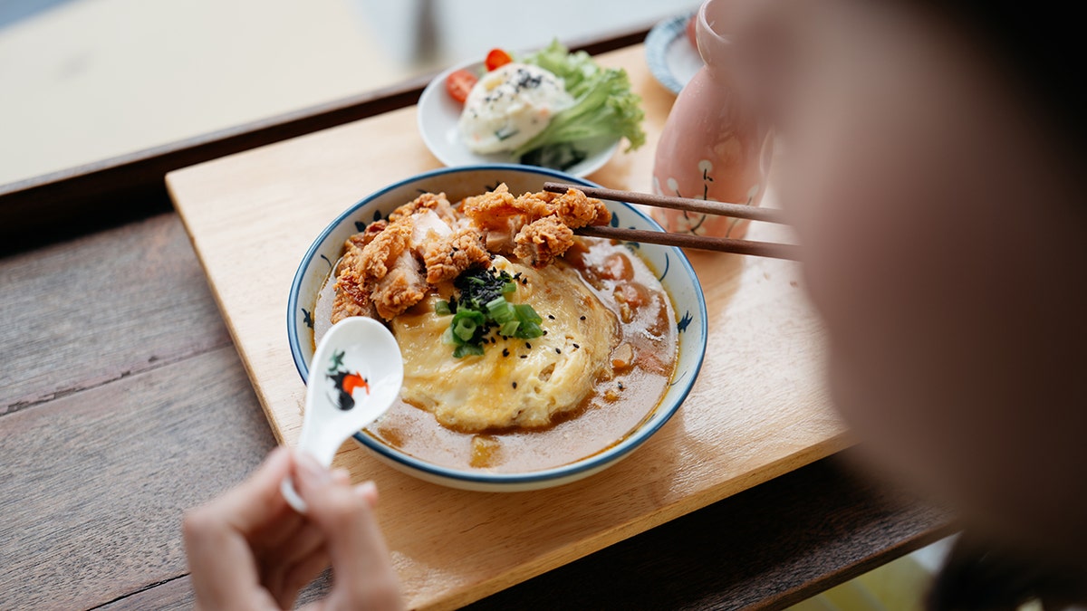 diner eats curry rice dish in restaurant