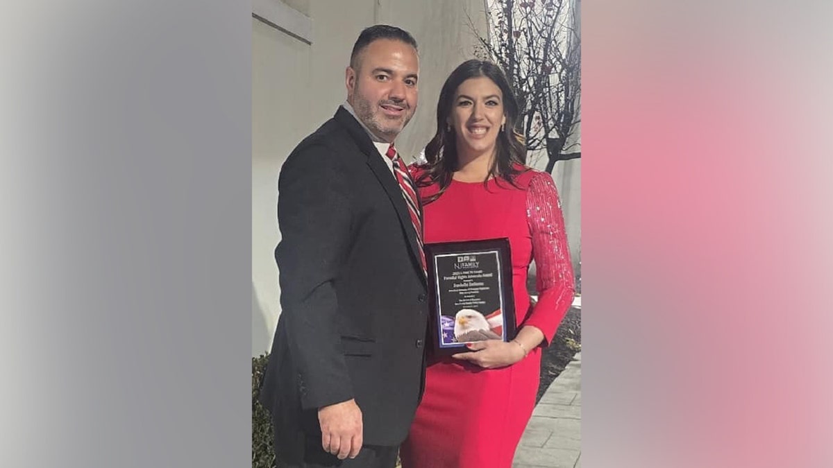Danielle Bellomo holds up an award