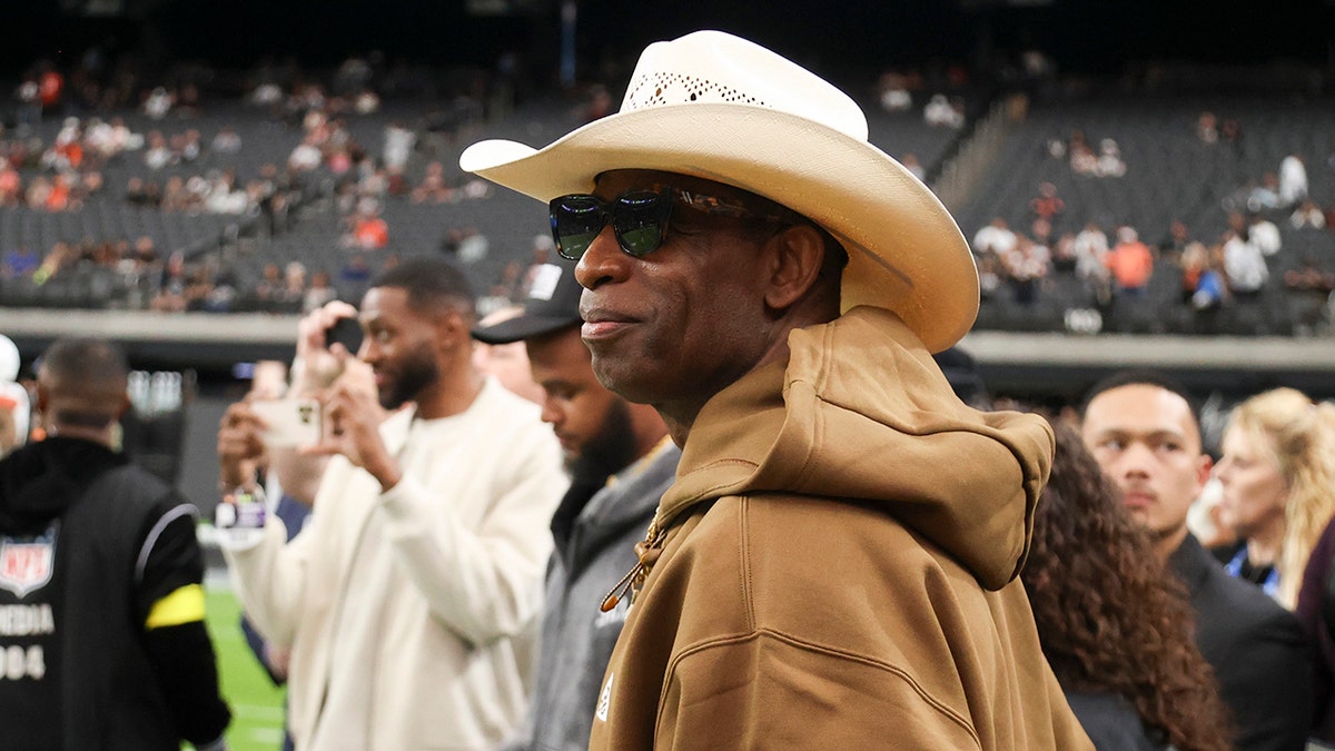 Deion Sanders looks on field