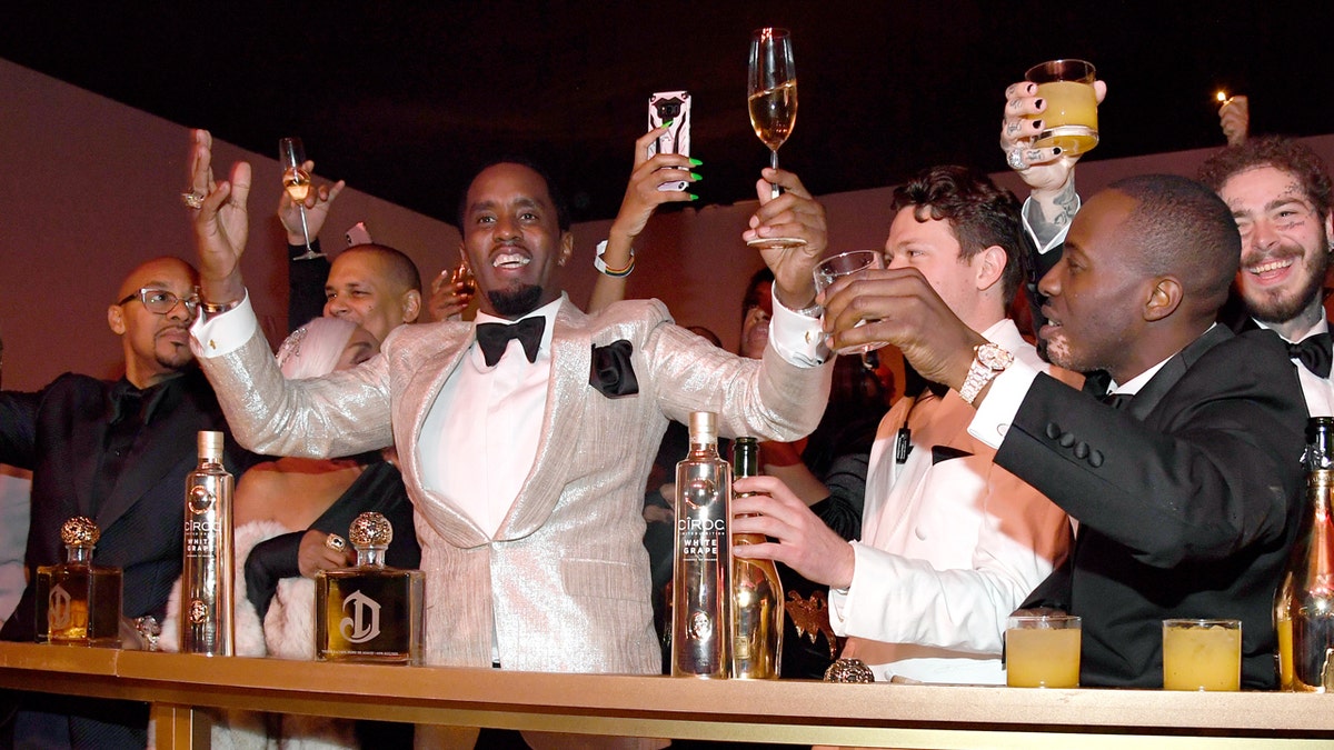 Diddy holds up a glass while celebrating his birthday