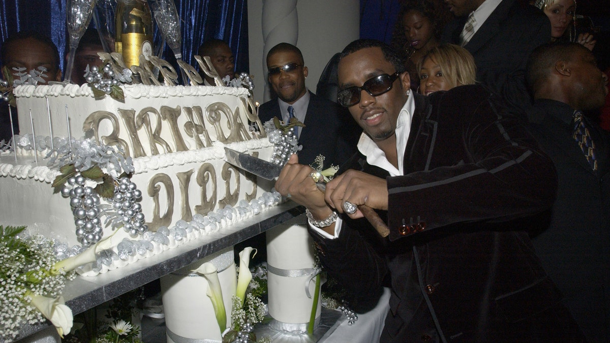 Diddy holds a knife to his birthday cake