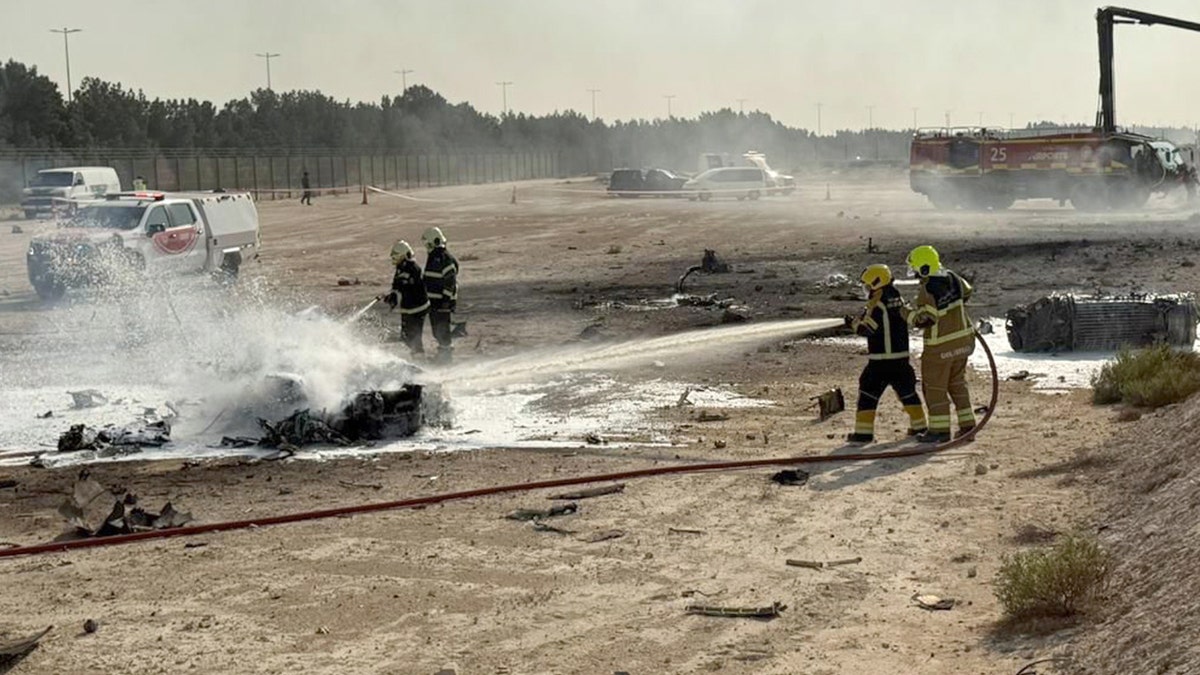 First responders douse water on debris after plane crashes at Dubai Air Show