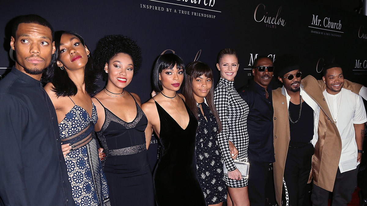 Eddie Murphy, Paige Butcher, and Murphy’s children pose together on the red carpet.