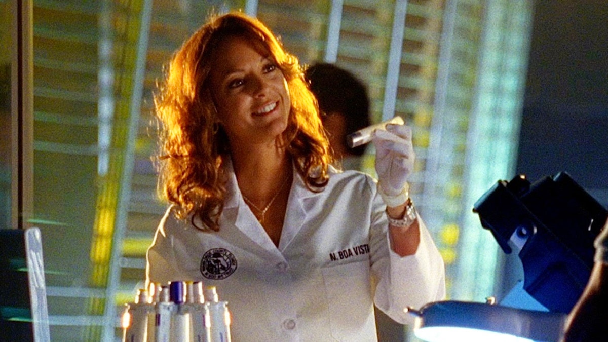 Eva LaRue wearing a lab coat and in character while filming a scene for "CSI: Miami."