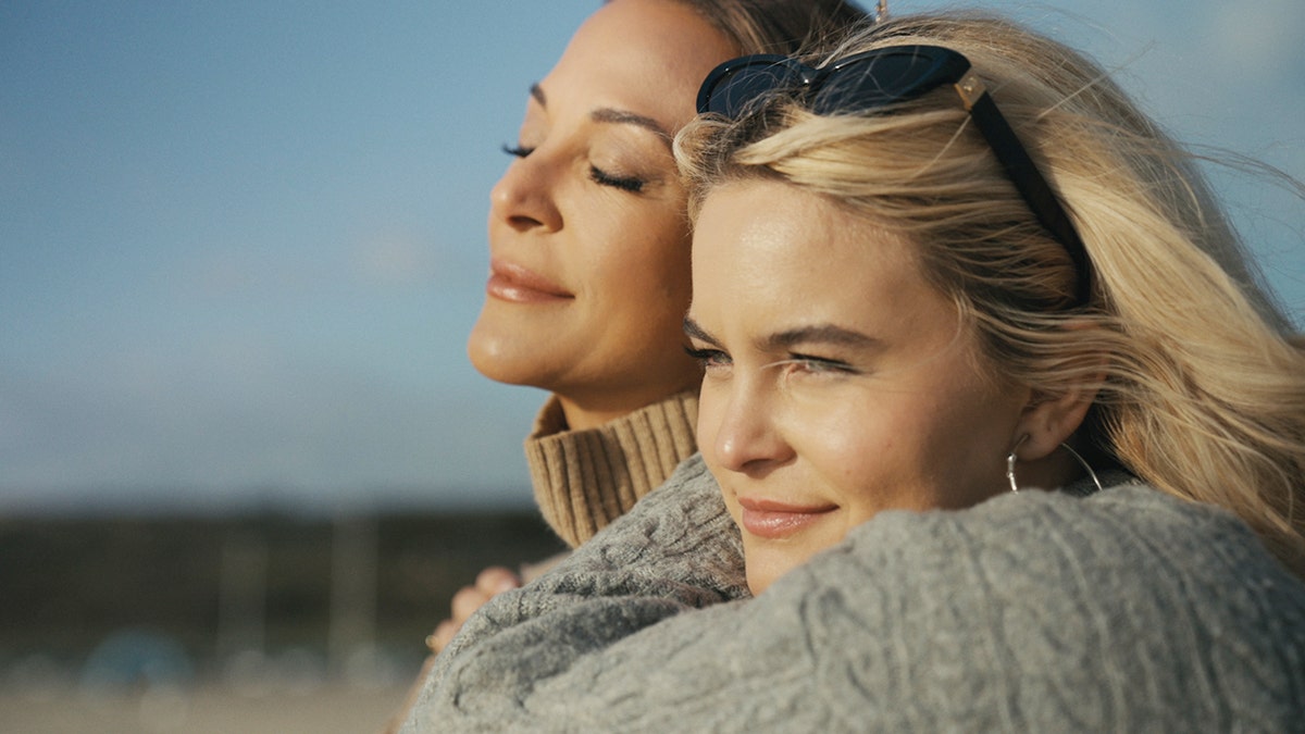 Eva LaRue with her eyes closed as her daughter Kaya Callahan holds her.