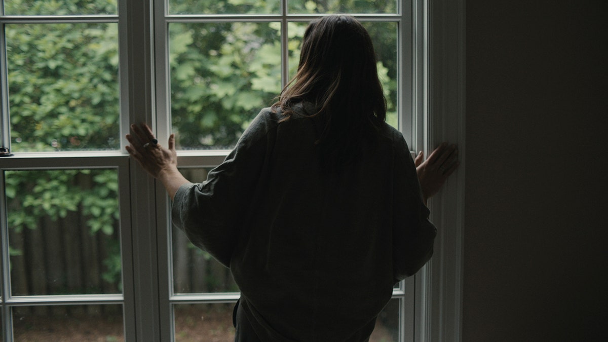 Eva LaRue looking out the window.