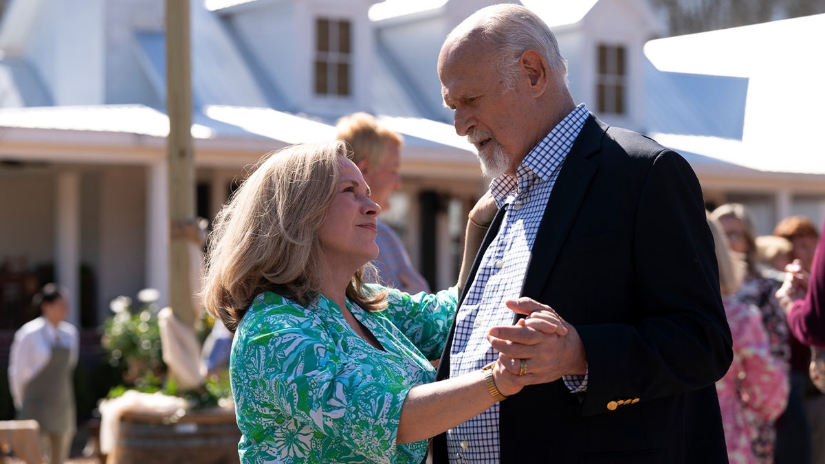 Patricia Arquette and Gerald McRaney dance together outdoors during a party scene in Murdaugh: Death in the Family episode