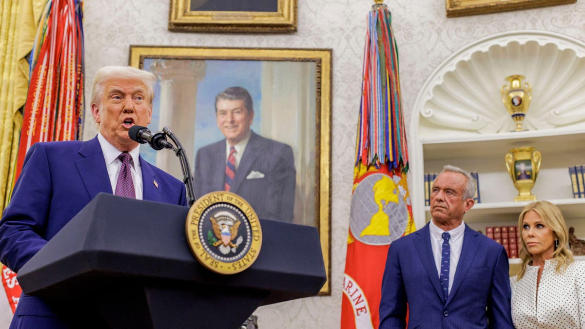 El presidente Donald Trump, desde la izquierda, Robert . F. Kennedy Jr., secretario de Salud y Servicios Sociales (HHS), y su mujer, la actriz Cheryl Hines, durante una ceremonia en el Despacho Oval de la Casa Blanca.