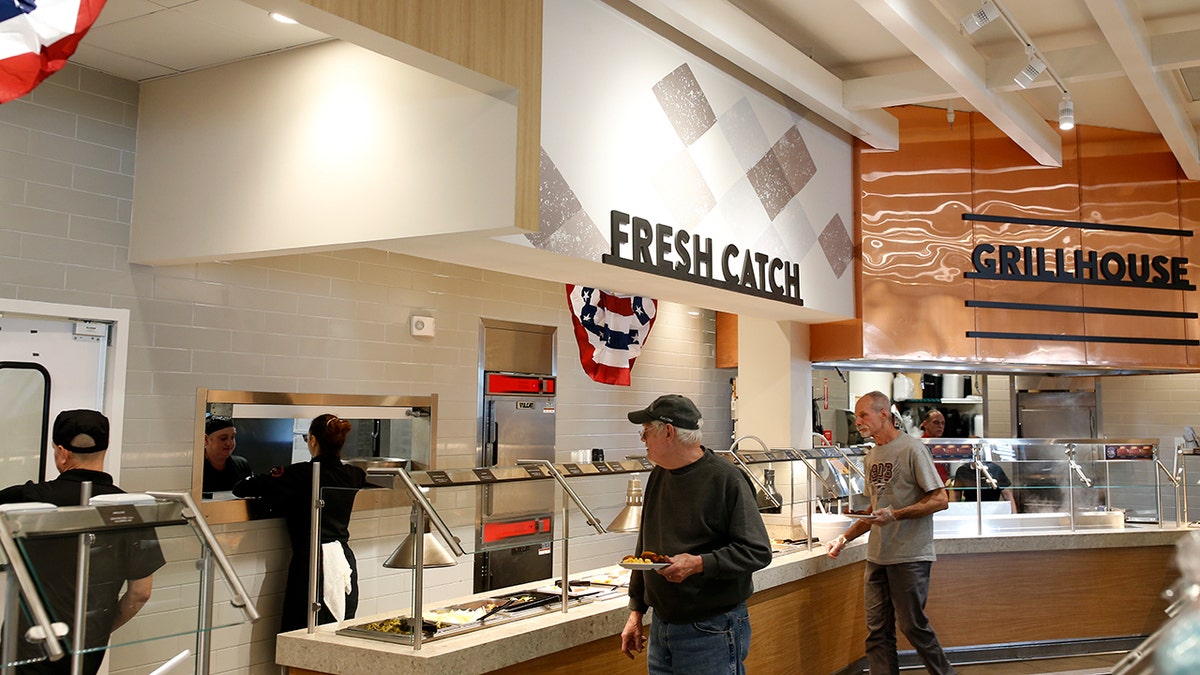 Older guests grab food from a Golden Corral buffet.