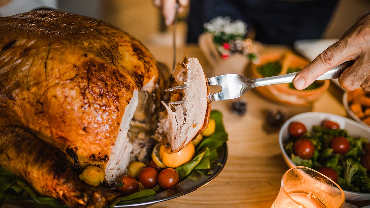 Woman carving turkey on Thanksgiving