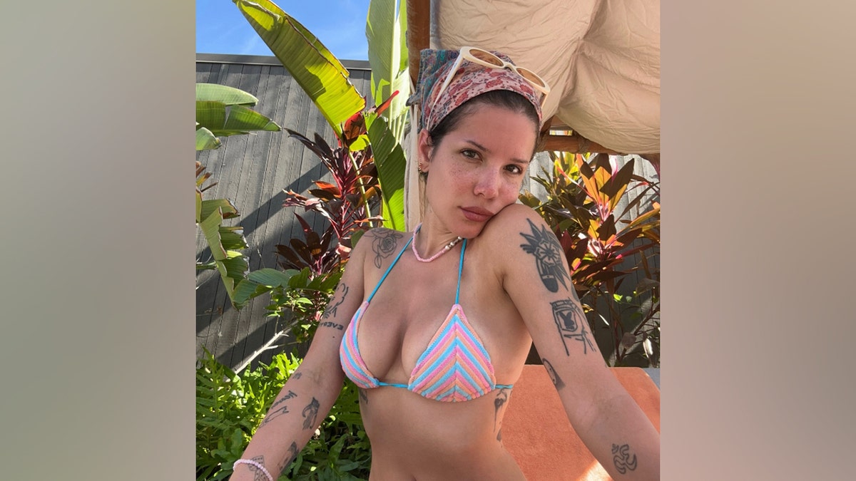 Halsey shows off a pastel striped bikini as she soaks up the sun during her vacation in Hawaii.