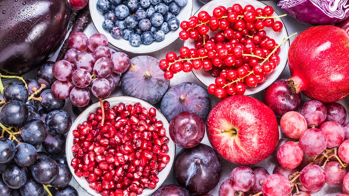 Coleção de frutas saudáveis ​​para o coração e ricas em flavanol, incluindo uvas, romã, ameixas e frutas vermelhas