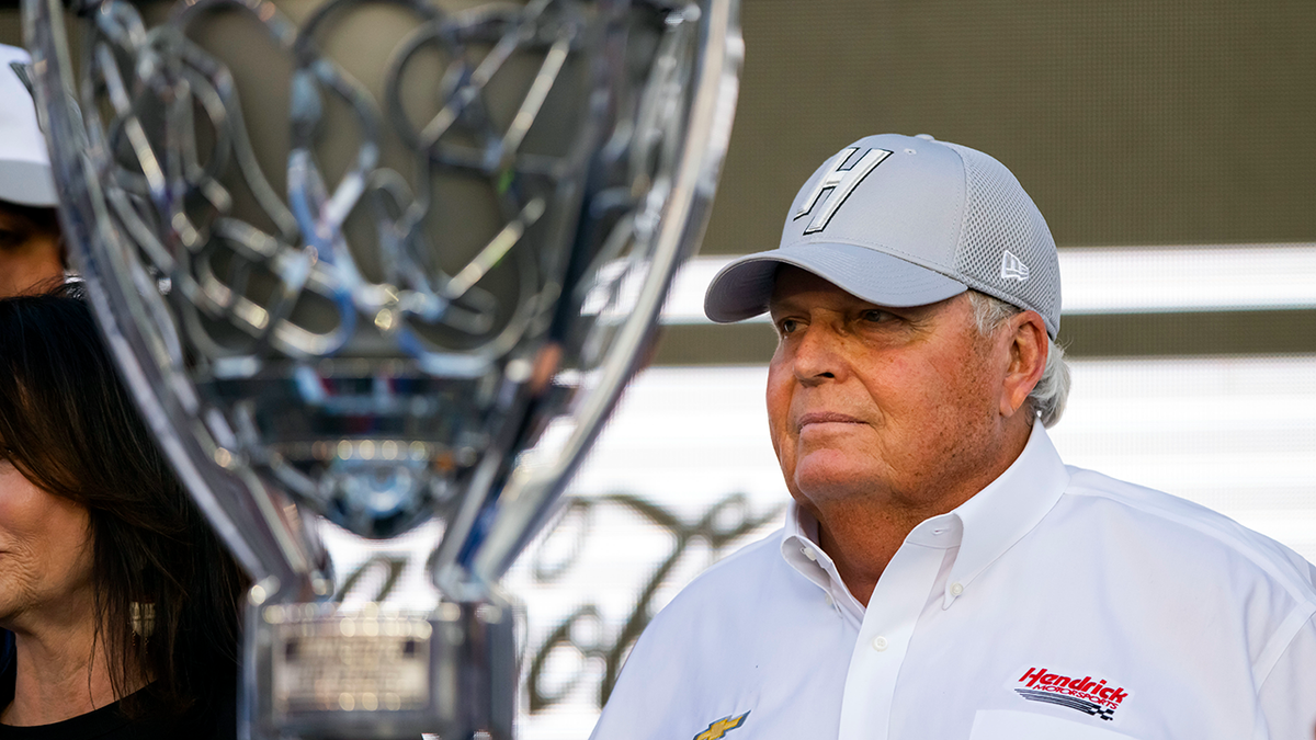 NASCAR championship trophy and Rick Hendrick beside it.
