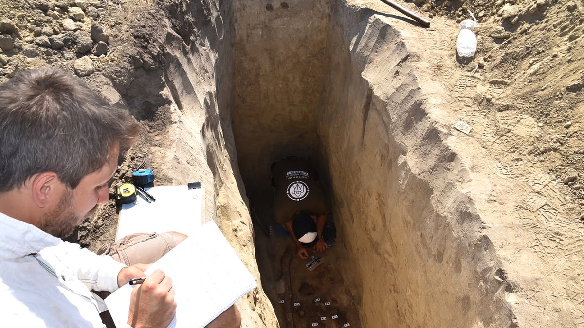 Archaeologists moving   supra  grave