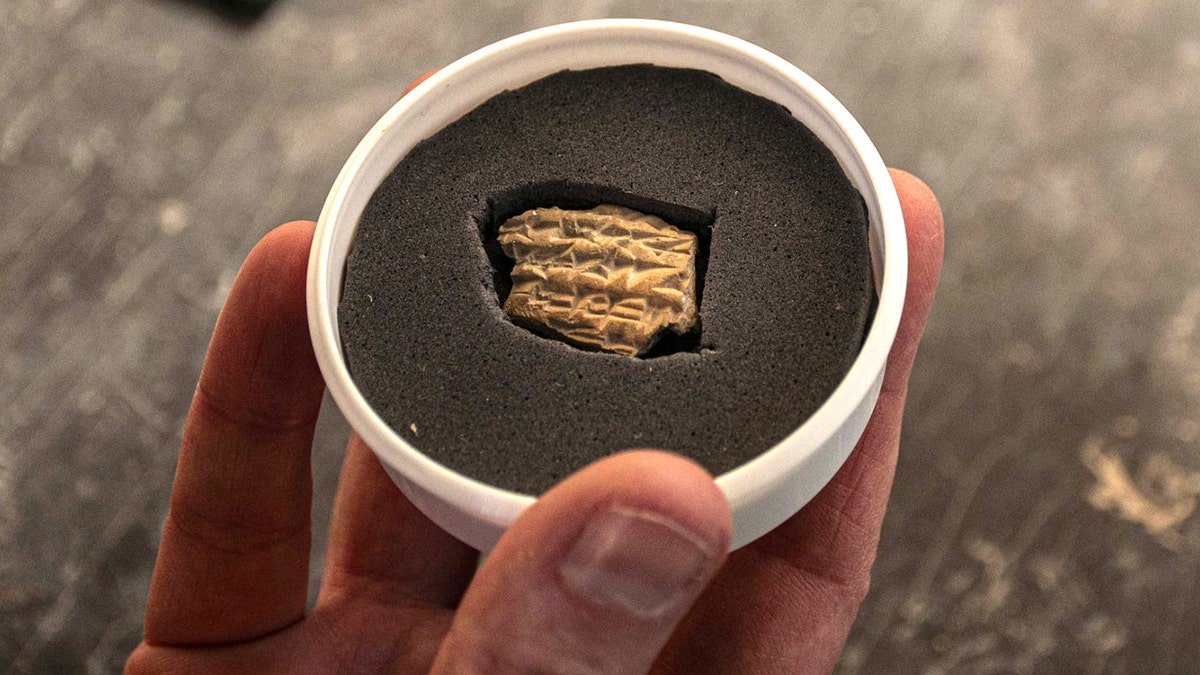 Hand holding tiny Akkadian fragment