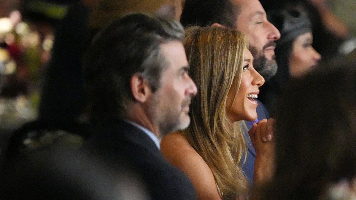 Jennifer Aniston laughs with Jim Curtis. 