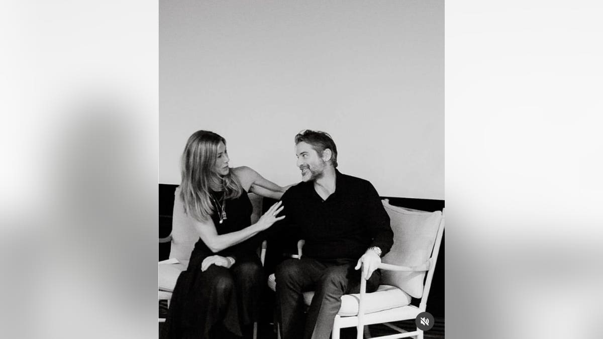 Jennifer Aniston sits next to boyfriend Jim Curtis