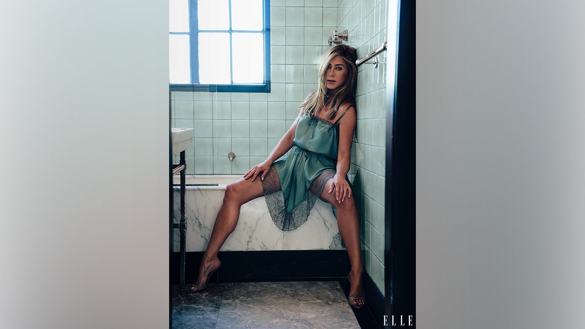 Jennifer Aniston poses in a blue-green slip dress during her Elle Women in Hollywood photo shoot