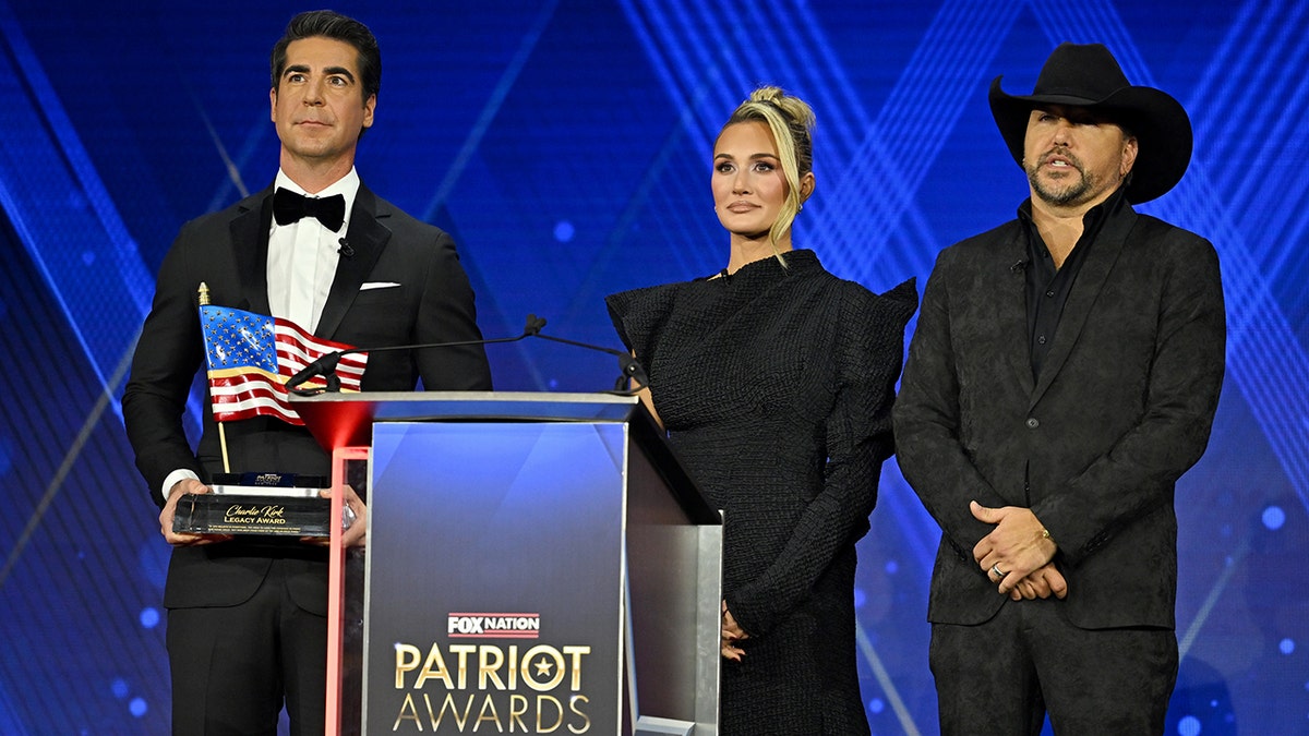 Jesse Watters, Brittany Aldean and Jason Aldean on stage at the Patriot Awards in November 2025.