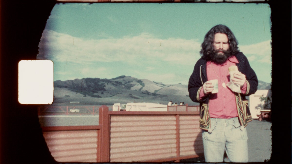 Jim Morrison eating on a bridge.