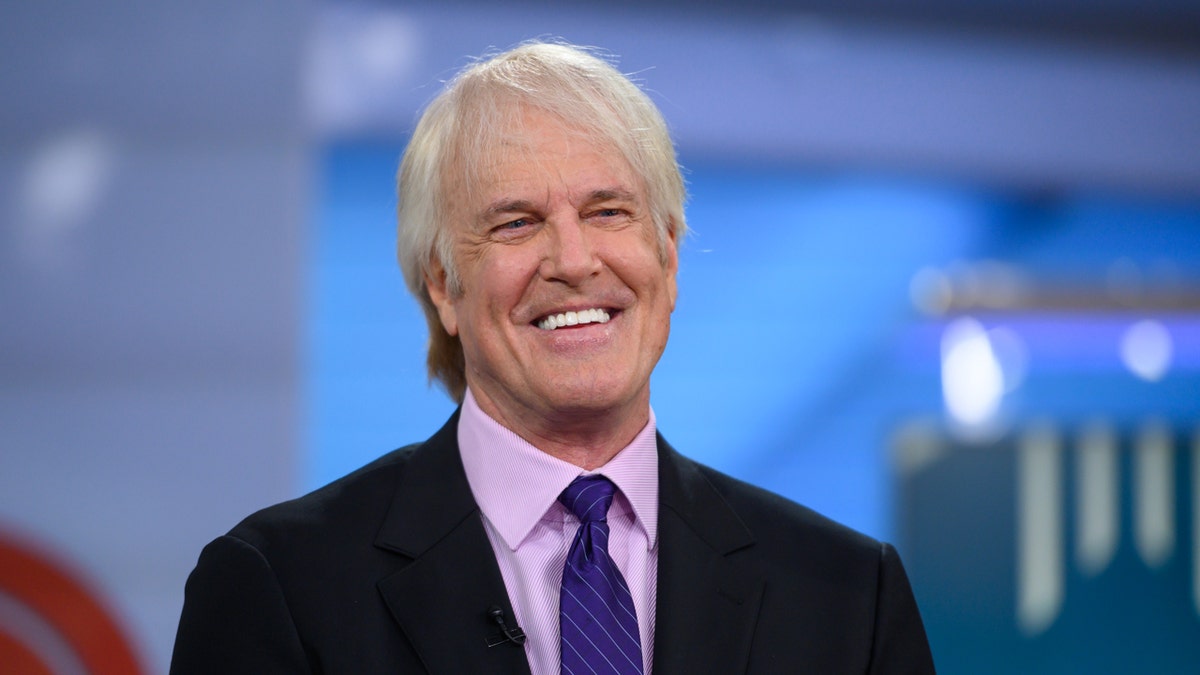 John Tesh smiles on TV