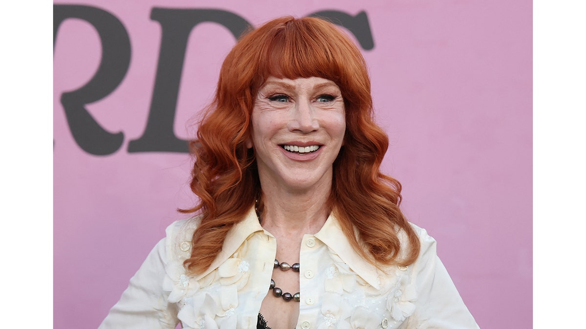 Kathy Griffin poses in front of a pink background
