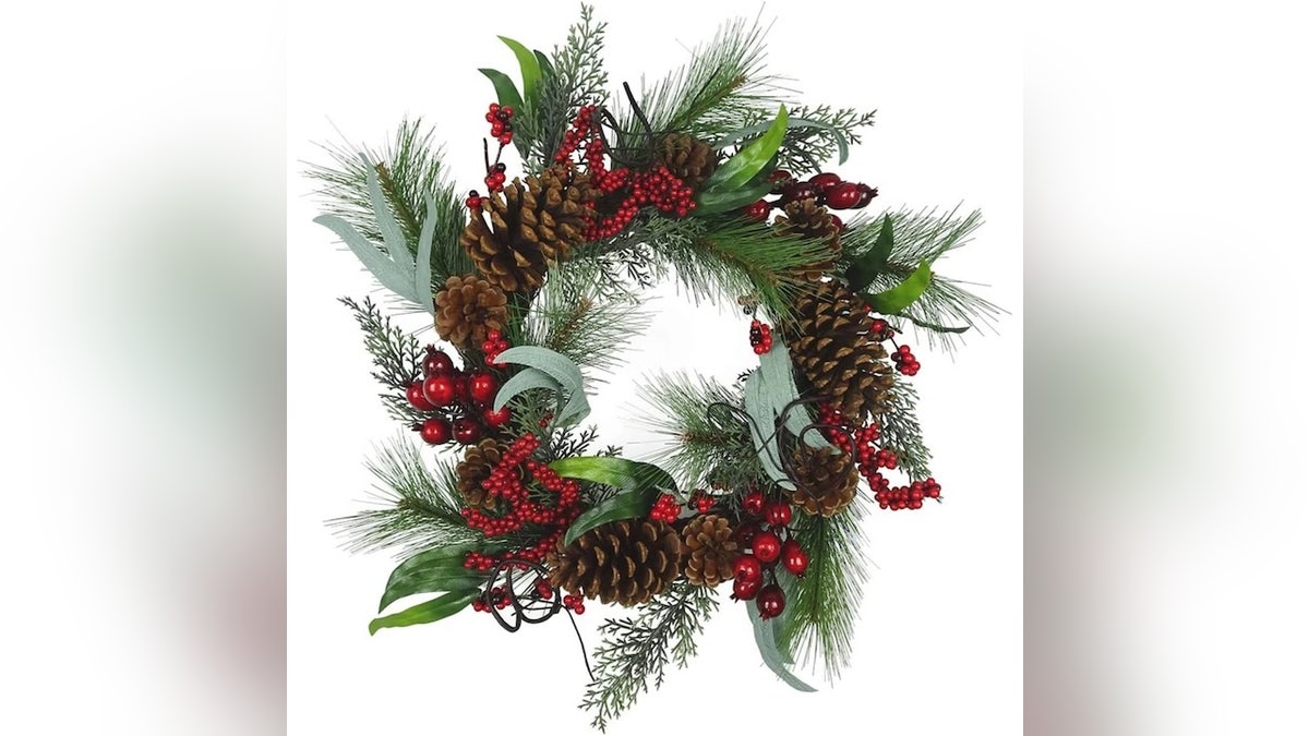 This wreath is flocked, frosted and adorned with berries and pine cones.