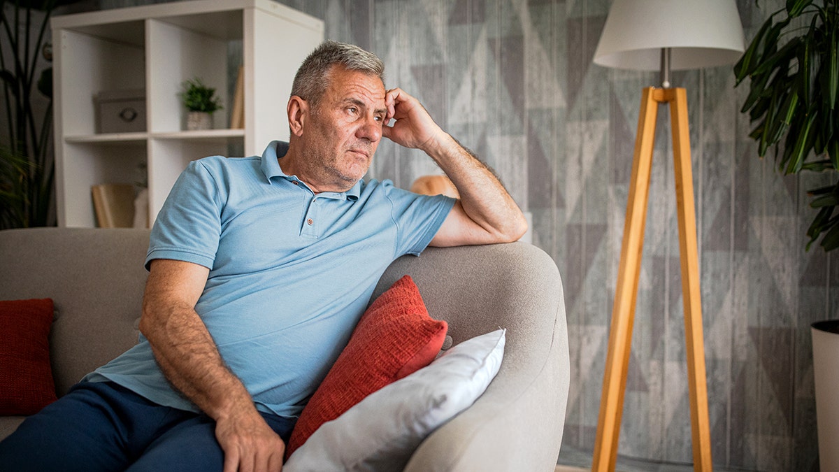 Old man in nursing home looking out window
