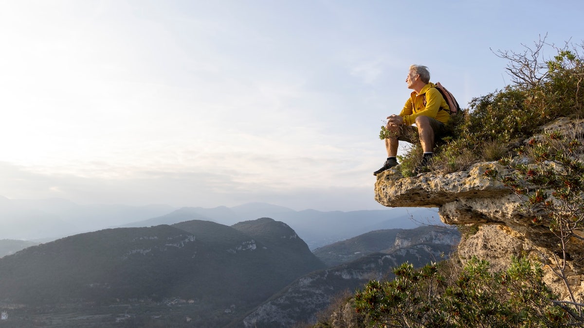 Man sitting on edge of cliff