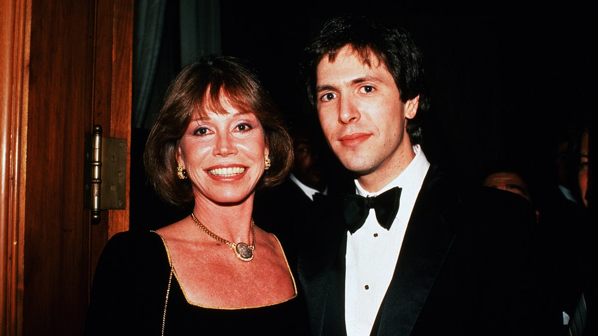 A close-up of Mary Tyler Moore smiling next to her husband Dr. S Robert Levine in a tux.