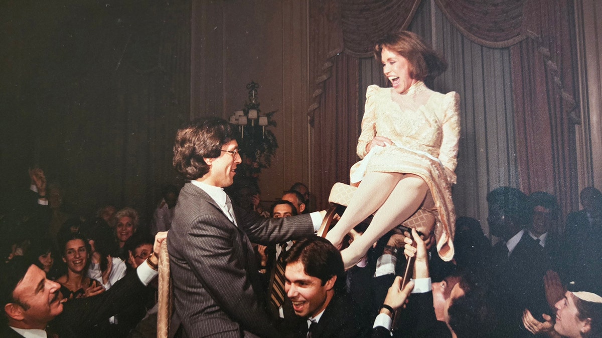 Mary Tyler Moore laughing on her wedding day as she's raised from a chair.
