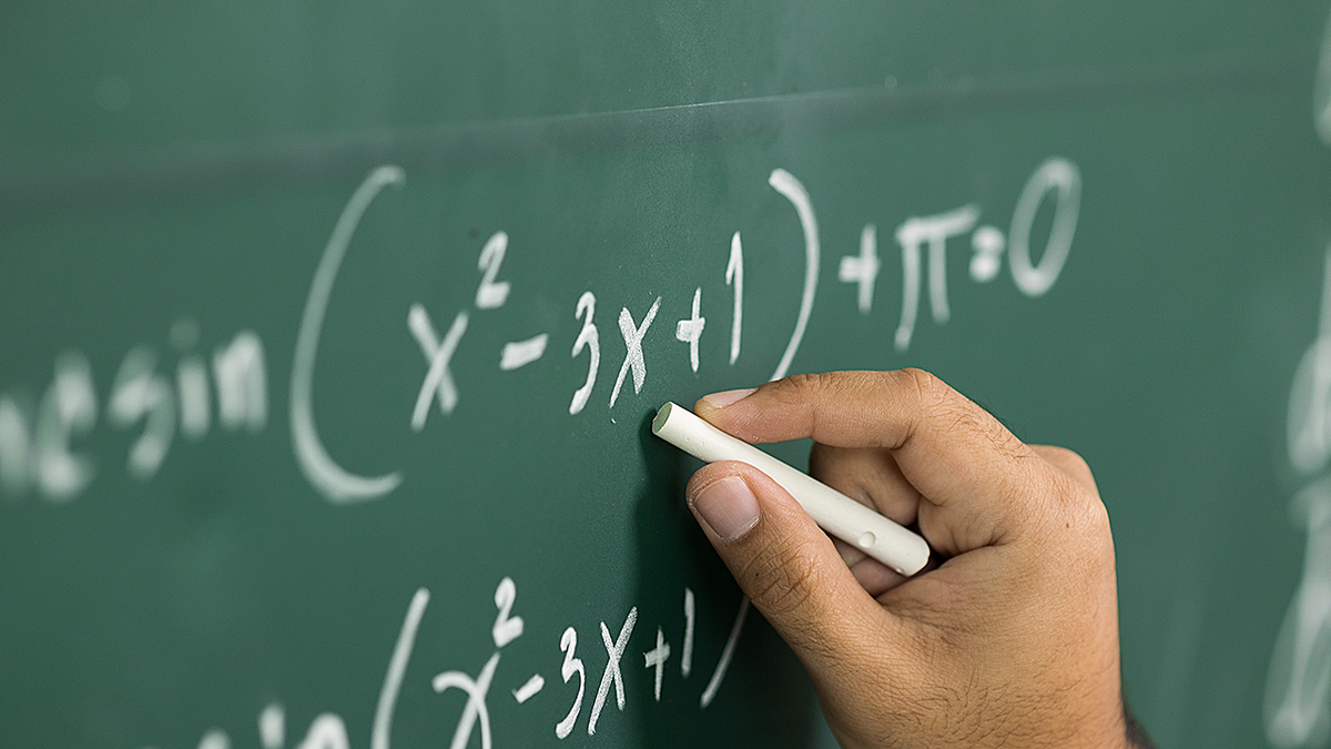 Person doing math equations on chalkboard