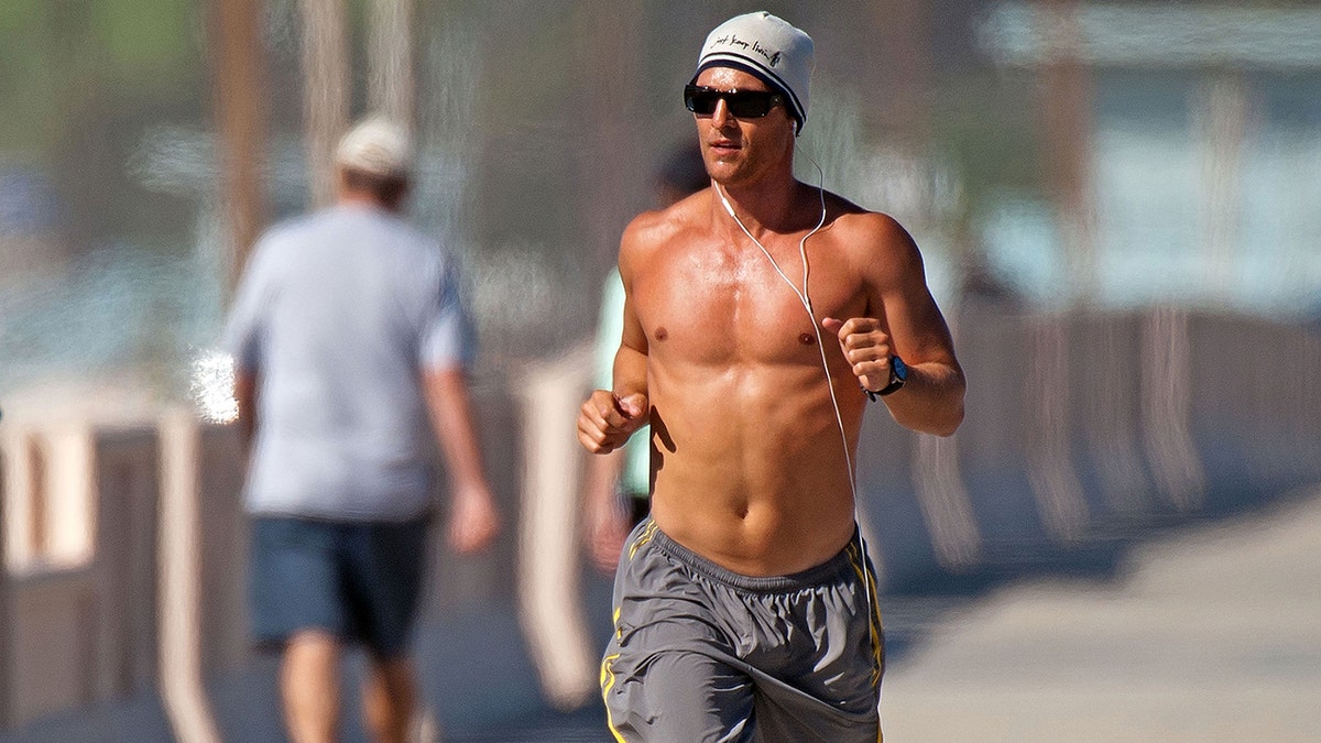 Matthew McConaughey running on the beach shirtless in January 2011