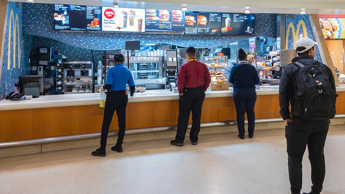 People seen from behind ordering at McDonald's in Orlando airport.