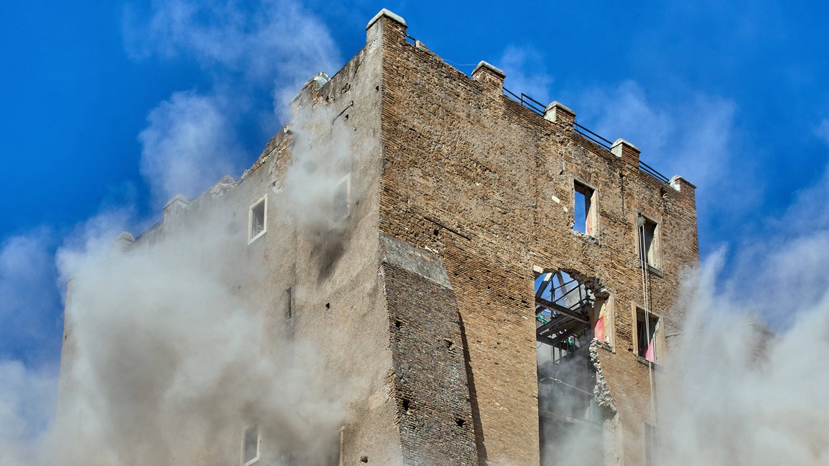 Worker dies after 11-hour rescue from collapsed medieval tower in Rome 3 medieval tower Torre dei Conti building collapse with clouds of debris