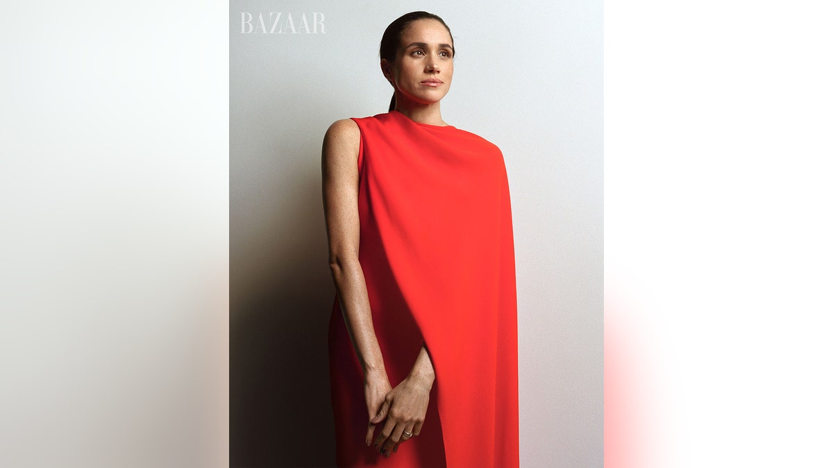 Meghan Markle wearing a long red sleeveless dress.
