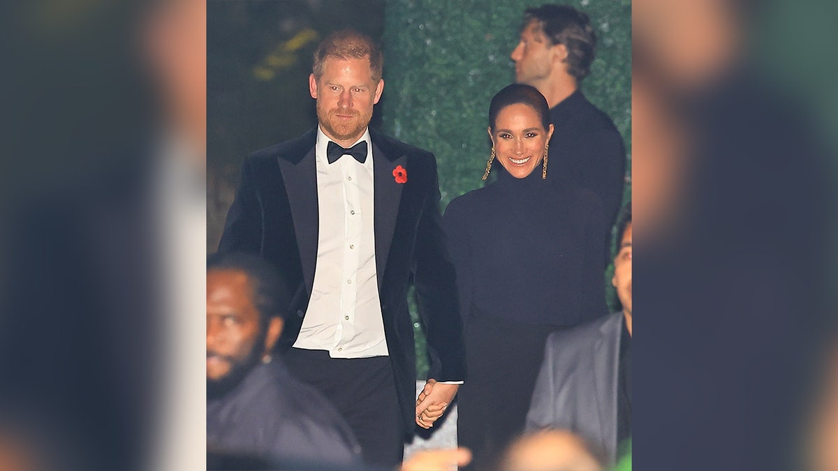 Prince Harry holds Meghan Markle's hand walking into Jeff Bezos' home.