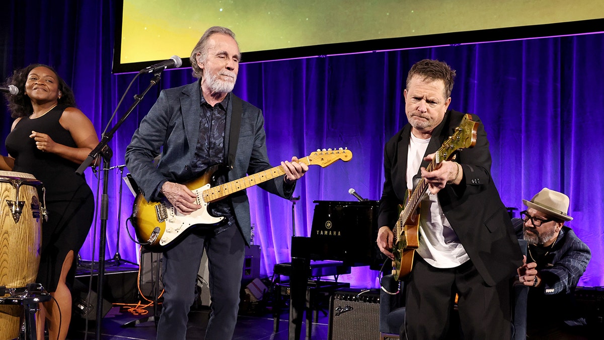 Michael J. Fox playing the guitar on stage