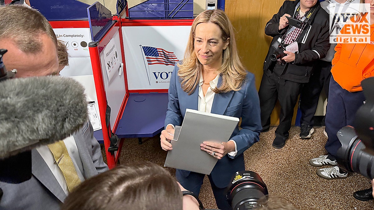 La representante Mikie Sherrill se encuentra cerca de una cabina de votación, rodeada de reporteros, después de emitir su voto en Montclair, Nueva Jersey.