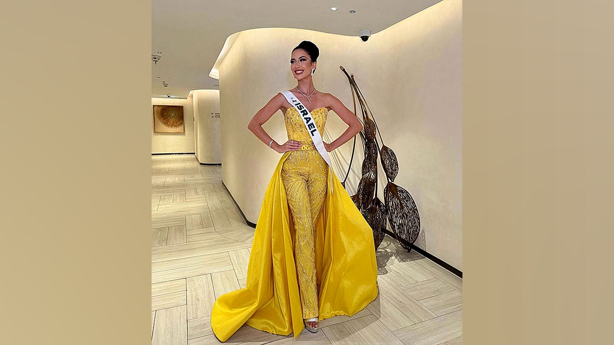 Miss Israel posing in a yellow dress.