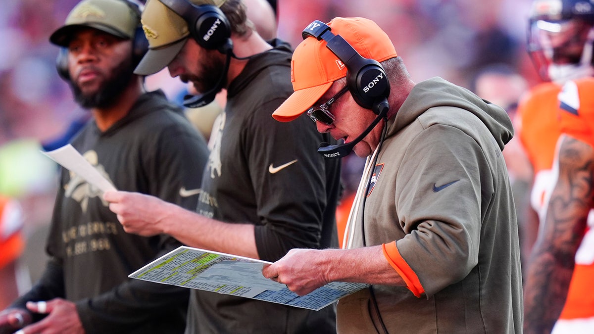 Sean Payton intently reading his play sheet