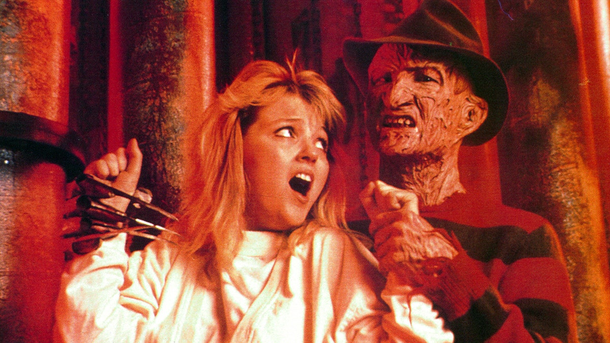 Freddy Krueger holding onto his victim as she screams/